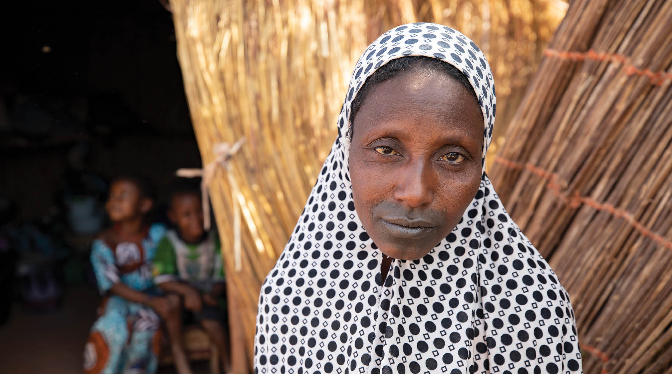 El campamento de Senou está situado en el extremo sur de Bamako, la capital de Malí Es uno de los ocho campamentos informales que hay en la ciudad y alberga a 223 familias y algo más de 1.000 desplazados internos Las familias que viven aquí han huido de la violencia y la insurrección en el norte y el centro del país Porque la mayoría de ellas carecen de medios de subsistencia o de una fuente regular de alimentos, Aquí, Fatima Bolly (33) sentada frente a su refugio improvisado La Sra. Bolly cuida de sus ocho hijos en el campamento mientras su marido permanece en el campo buscando trabajo No ha recibido ninguna ayuda de él desde que se separaron, y ha tenido que depender de la amabilidad de los vecinos para conseguir los alimentos que han recibido Crisis del Sahel 2021; Senou, Malí 24 de febrero de 2021 Foto de Jake Lyell 