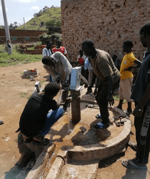 Des cyclistes testent le fonctionnement d'une pompe à eau manuelle à Kadugli, dans le Kordofan méridional.