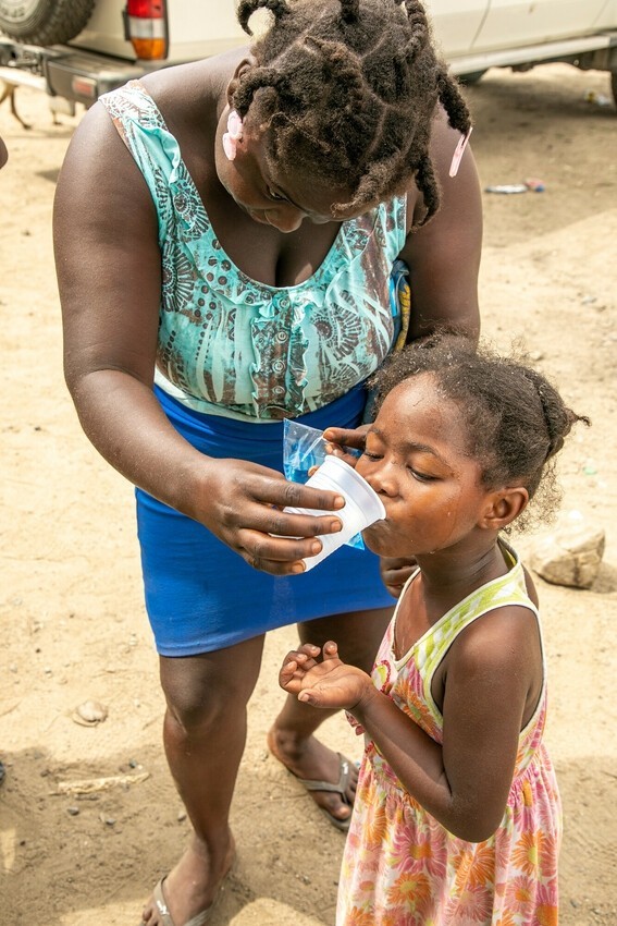 Une jeune fille consomme le traitement LF lors de la campagne MDA en Haïti.
