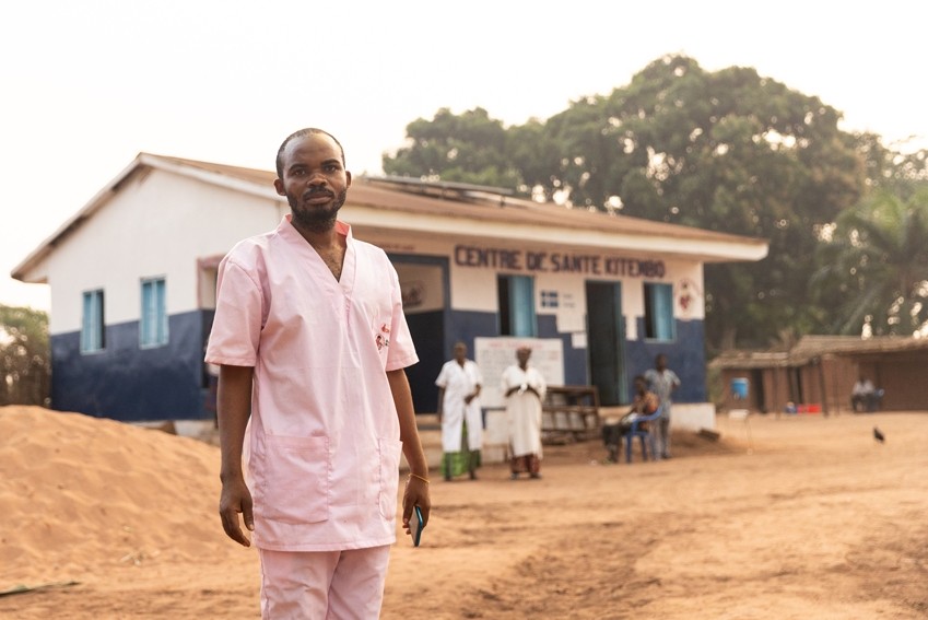 Nurse stands in front of health center in DRC