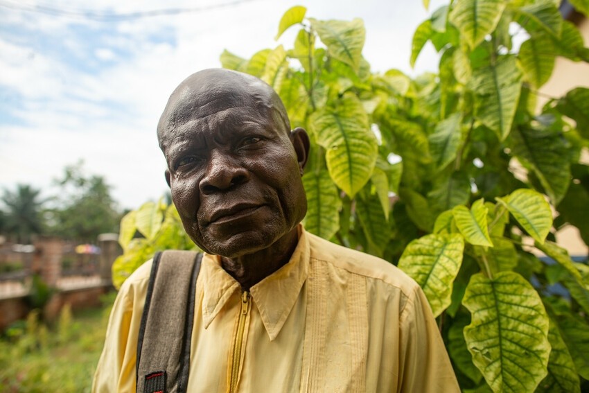 A community health worker poses in a garden