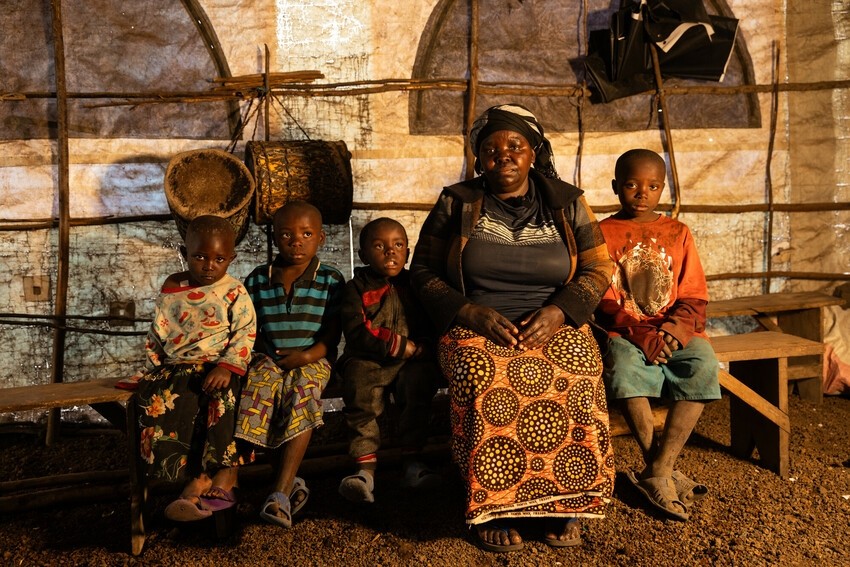 Fela Mbahibwe sits with her grandchildren in the makeshift church in the IDP camp