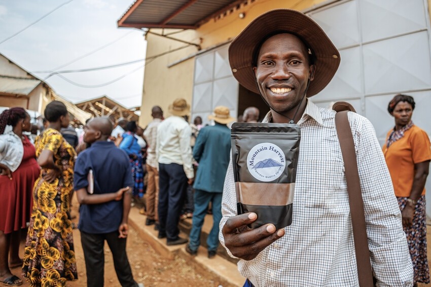 Man holding Mountain Harvest bag of coffee