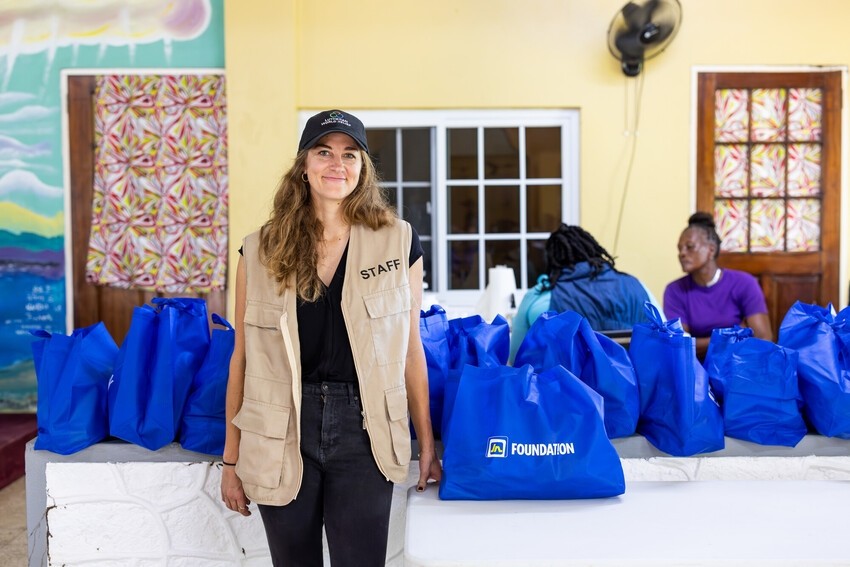 A humanitarian worker stands in front of food packages at a clinic
