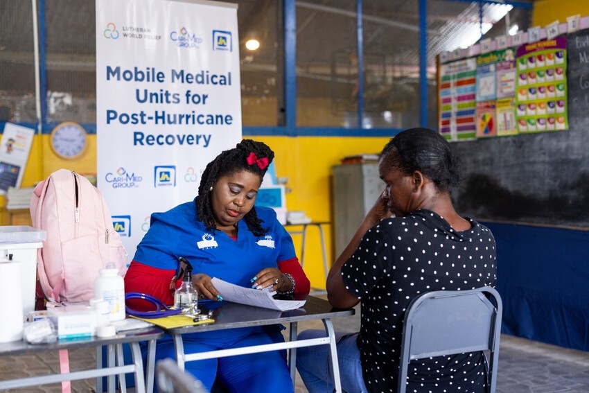 A health worker and local resident discuss care at a mobile health clinic