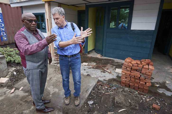 Dr. Kasereka “Jo” Lusi (left), an orthopedic surgeon who founded HEAL Africa, consults with Dr. Bill Clemmer, who led the Ebola response for IMA World Health, stand in front of an isolation unit for suspected Ebola patients at the entrance to the Heal Africa Hospital in Goma, the war-torn city in the eastern Democratic Republic of the Congo in 2019. The doctors are now working together to respond to COVID-19. (Photo by Paul Jeffrey)