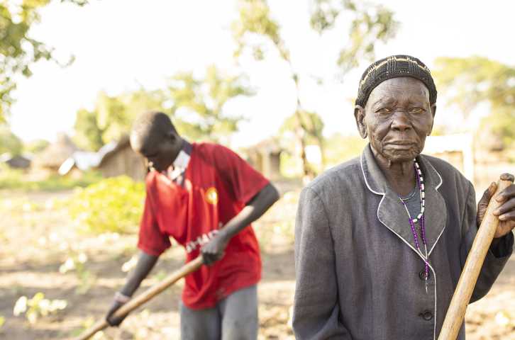 Philip Bidal, de 17 años, y su abuela Acii Paulina, de más de 80, son refugiados de Sudán del Sur que viven en el asentamiento de refugiados de Palabek, en el norte de Uganda. Recibieron semillas mejoradas y formación agrícola de Lutheran World Relief para ayudarles a diversificar su dieta y aumentar sus ingresos. (Foto de Jake Lyell)
