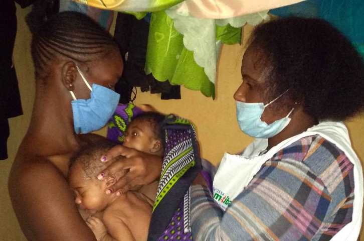 Lavender Atieno receives guidance from Afya Jijini Kangaroo Mother Care Champion Mary Wairimu, affiliated with Mama Lucy Kibaki Hospital, to practice the KMC technique at her home in Kayole in Nairobi County. 
