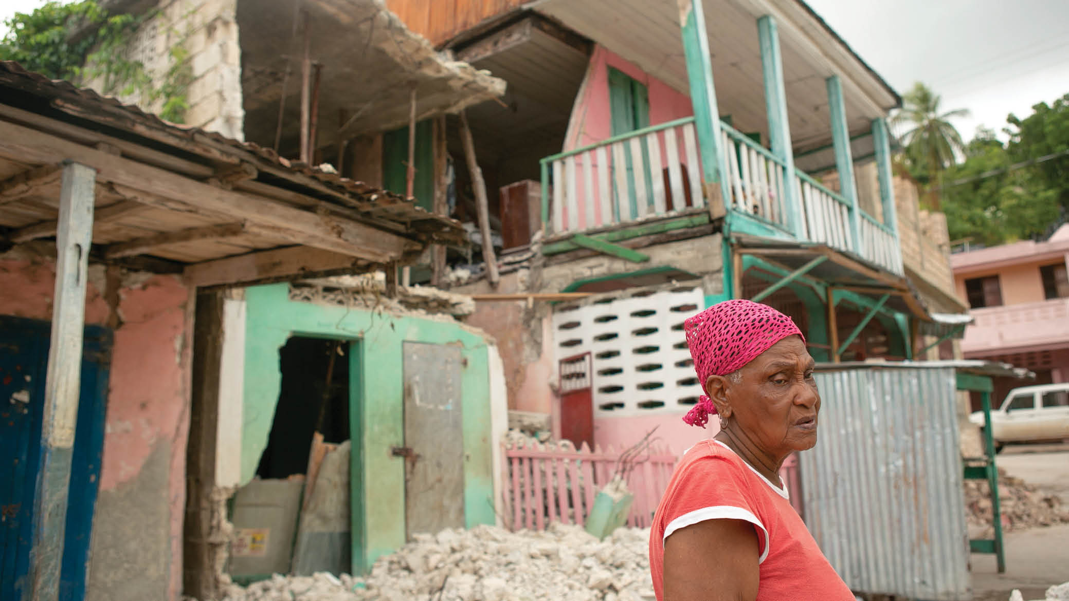 Philistein Victor, 81, stands in front of her home and that of her son, next door, both destroyed by the August 14 earthquake in Corail, in the Grand Anse department of Haiti, August 24, 2021  The fishing village was heavily damaged in the quake  (Photo by Allison Shelley for LWR Corus)