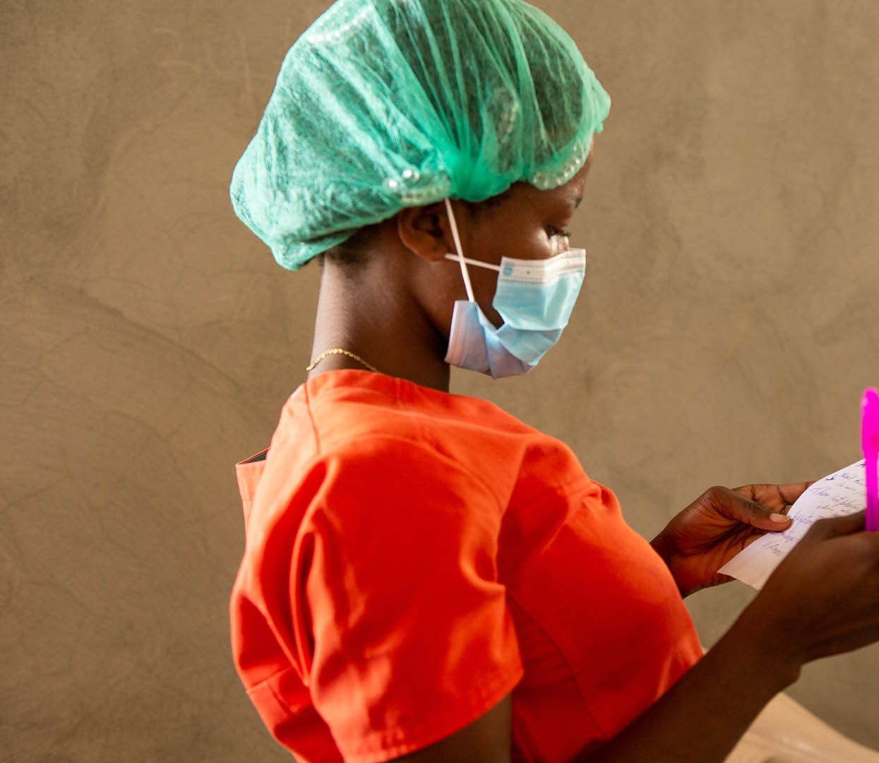 A medical professional goes over paperwork in a recovery ward full of quake victims at St  Antoine Hospital in Jeremie, Haiti, August 22, 2021, eight days after a 7 2 magnitude quake devastated the region  (Photo by Allison Shelley for LWR Corus)