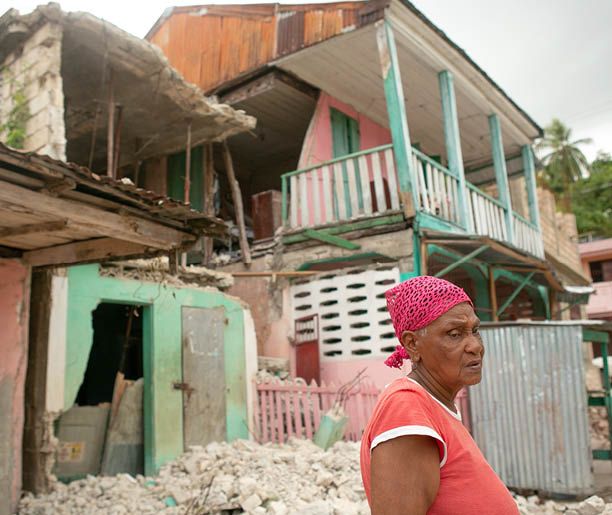 Philistein Victor, 81, stands in front of her home and that of her son, next door, both destroyed by the August 14 earthquake in Corail, in the Grand Anse department of Haiti, August 24, 2021  The fishing village was heavily damaged in the quake  (Photo by Allison Shelley for LWR Corus)