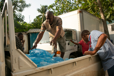 On the outskirts of Jeremie, Haiti, representatives from LWR Corus and the Swiss foundation HEKS EPER load a pickup truck with potable water sachets to deliver to quake-affected villages in the Grand Anse department of Haiti, August 24, 2021  A 7 2 magnitude quake rocked the region ten days earlier, causing heavy damage to this area  (Photo by Allison Shelley for LWR Corus)